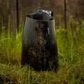 Indlæs billede i Gallery viewer, Vikingekrus Thors Hammer Horn (600-800 ml), et poleret sort hornkrus med et ætset design af Thors Hammer, vises på levende grønt græs mod en rustik træbaggrund.