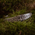 Indlæs billede i Gallery viewer, Et detaljeret Armbånd Armbånd Mjølnir lavet af 925'erne Sterling Sølv, med indviklede keltiske knudemønstre og et lille dragehoved i midten, sat mod en baggrund af frodigt grønt mos.
