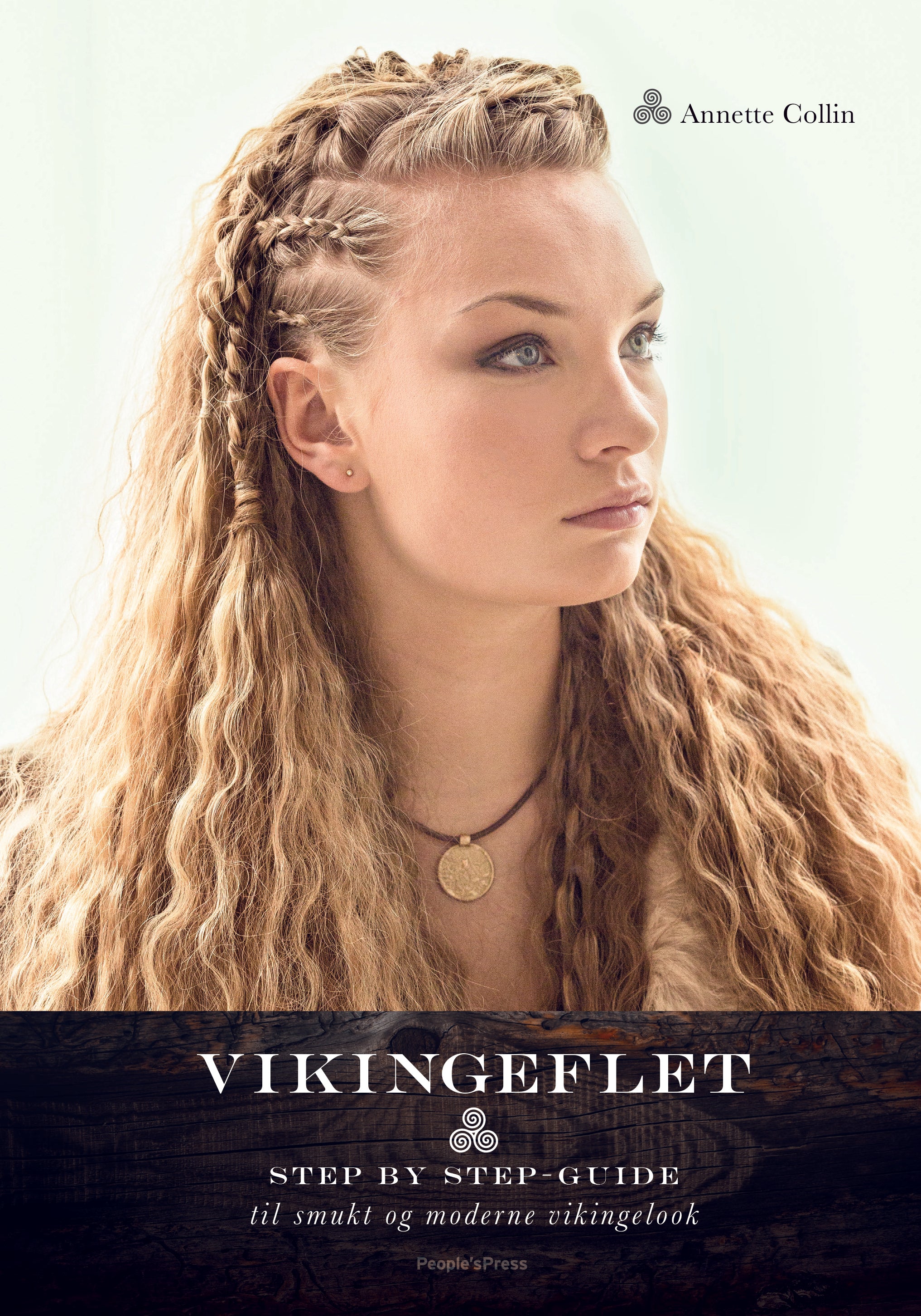 Forsiden af "Flettekursus med Anette Collin - 8/12-2022" viser en kvinde med langt flettet hår stylet på en vikinge-inspireret måde, der kigger til siden. Hun er klædt i et pelsbeklædt tøj og har et cirkulært vedhæng. Forfattet af Anette Collin giver denne bog en trin-for-trin guide i workshop-stil til at opnå moderne vikingelooks.